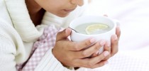 Woman Holding Cup of Water and Lemon