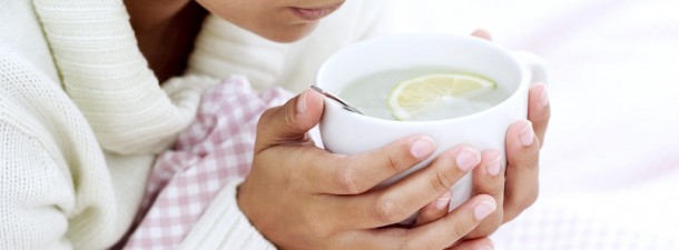Woman Holding Cup of Water and Lemon